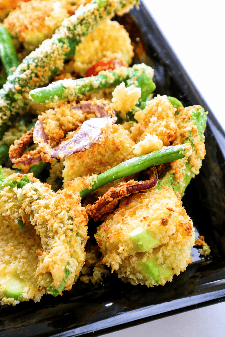 Plate of golden air fryer vegetable tempura with zucchini, sweet potato, and green beans