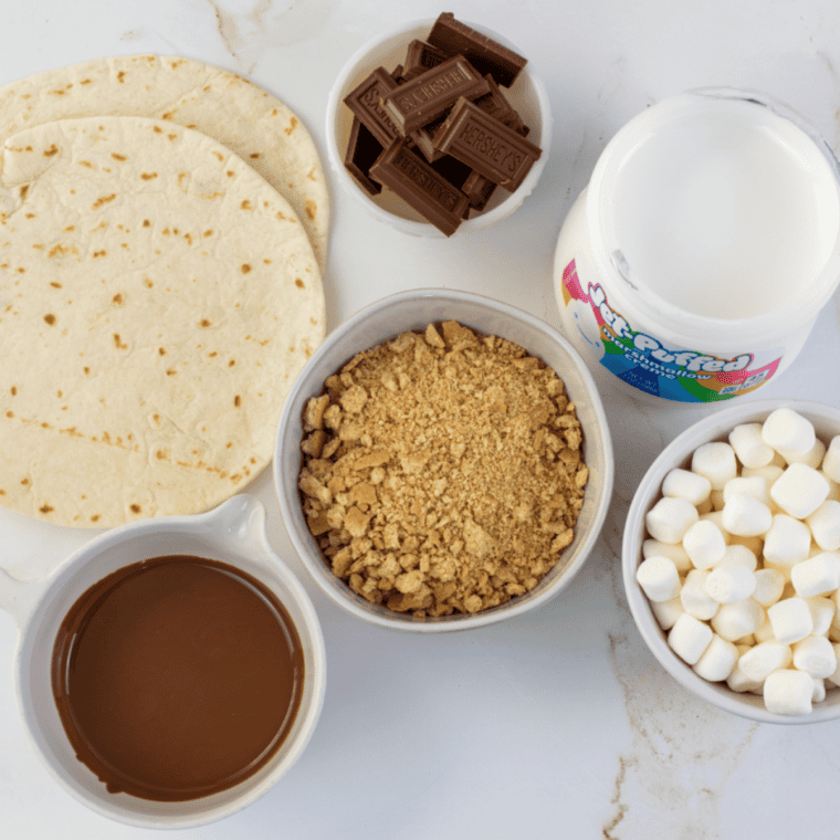Ingredients needed for Easy Blackstone Grill S’mores Pizza on kitchen table.