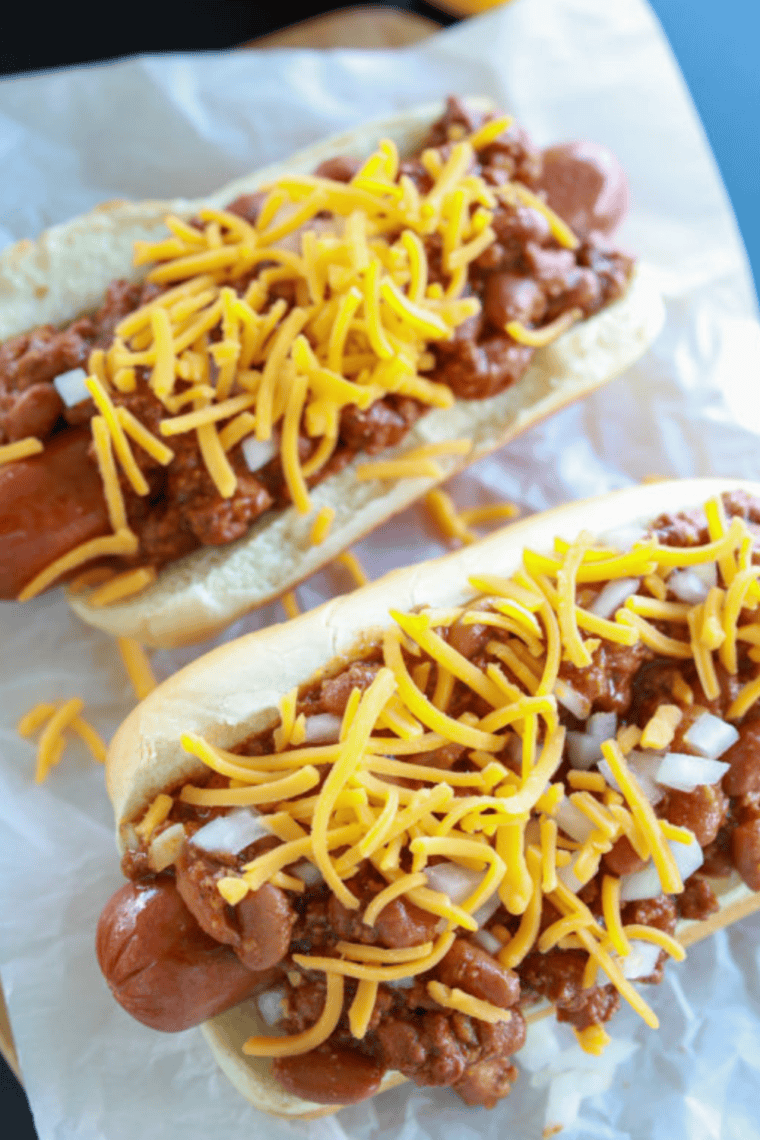 Hot dogs sizzling on a Blackstone flat top griddle with crispy browned edges and grill sear marks cooking evenly.