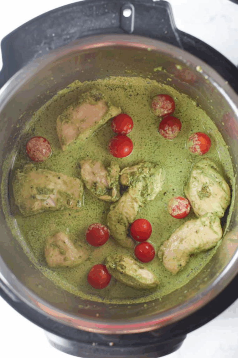Pesto-coated chicken sautéing in the Instant Pot with a bit of oil, ready to be deglazed with chicken stock