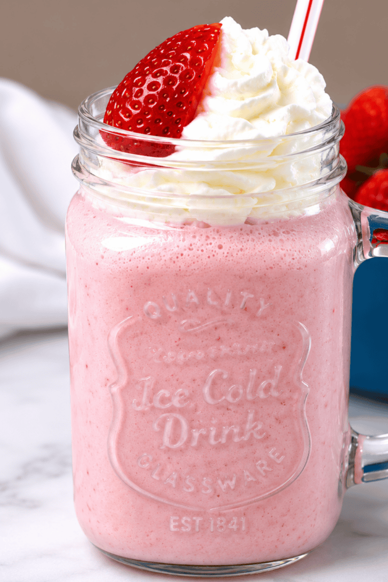 Mason jar filled with a thick, creamy Ninja Creami strawberry milkshake