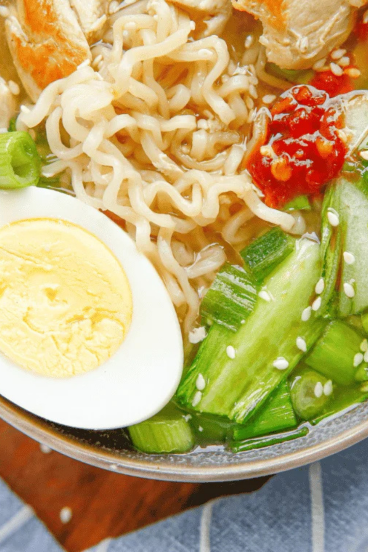 slow cooker chicken ramen with shredded chicken, soft boiled egg and nori in a dark bowl