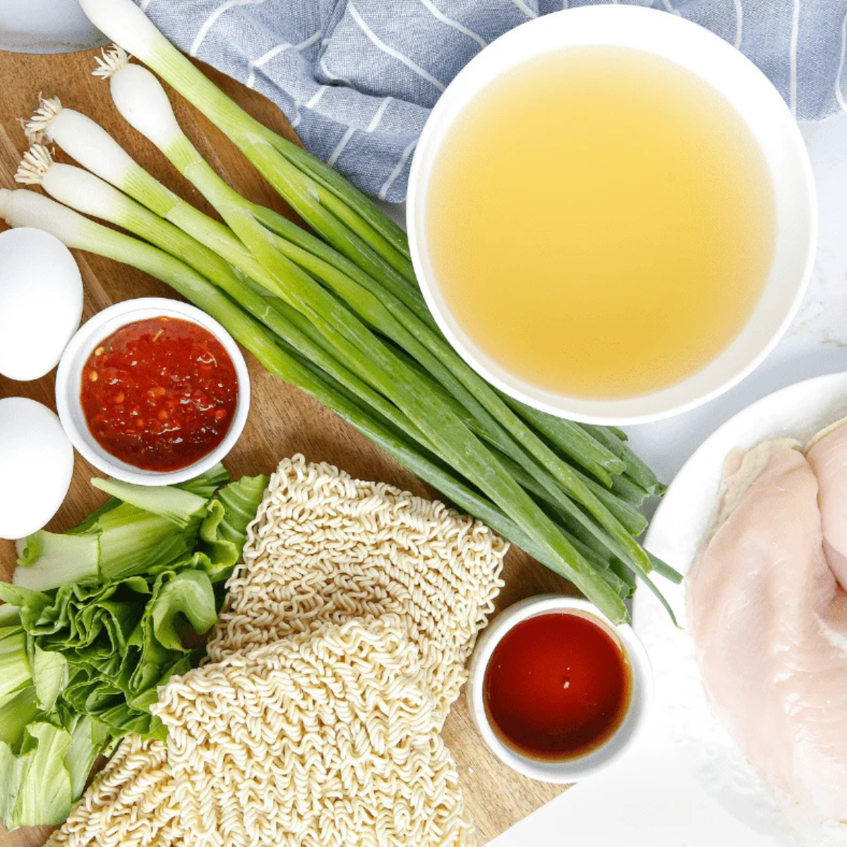 ingredients for slow cooker chicken ramen including chicken thighs, miso, soy sauce, ginger and dried shiitakes