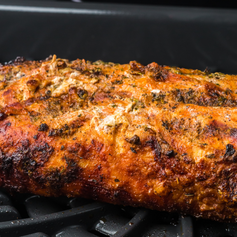Golden-brown Traeger smoked pork tenderloin sliced on a serving platter