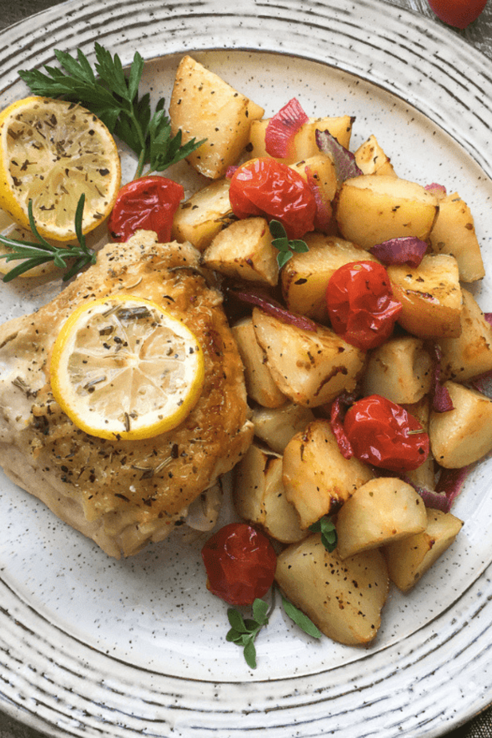 Air fryer roasted potato wedges and cherry tomatoes, golden and tender, served on a plate.