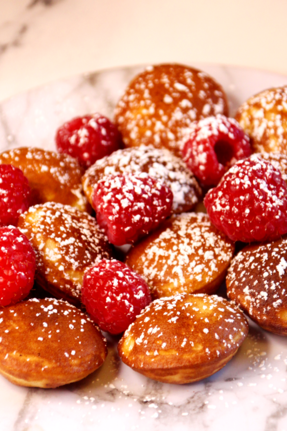 Crispy air fryer Trader Joe’s pancake puffs stacked on a plate with powdered sugar