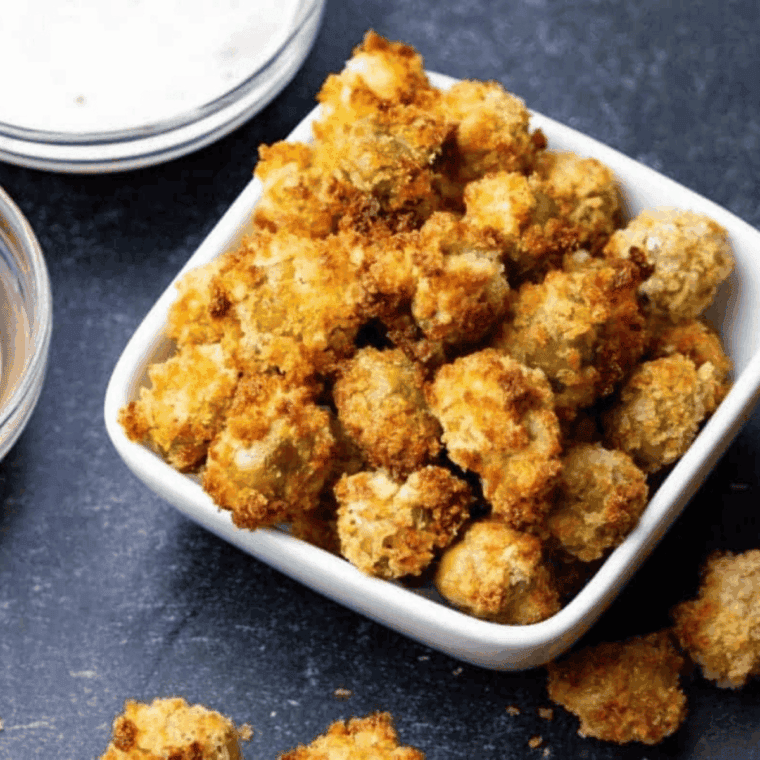 Crispy golden air fryer fried olives served on a white plate with dipping sauce.