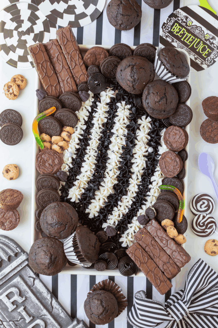Beetlejuice-inspired buttercream board with black, white, purple, and green striped frosting.
