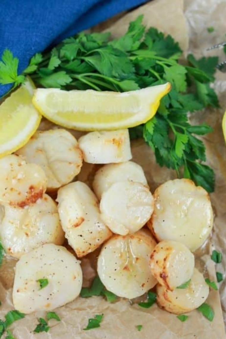 Blackstone griddle scallops seared golden brown and topped with lemon herb butter.