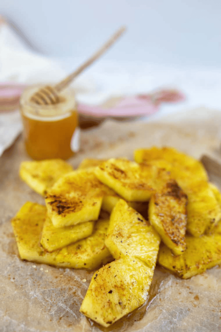 Golden pineapple slices cooking on a Blackstone griddle, caramelized and juicy