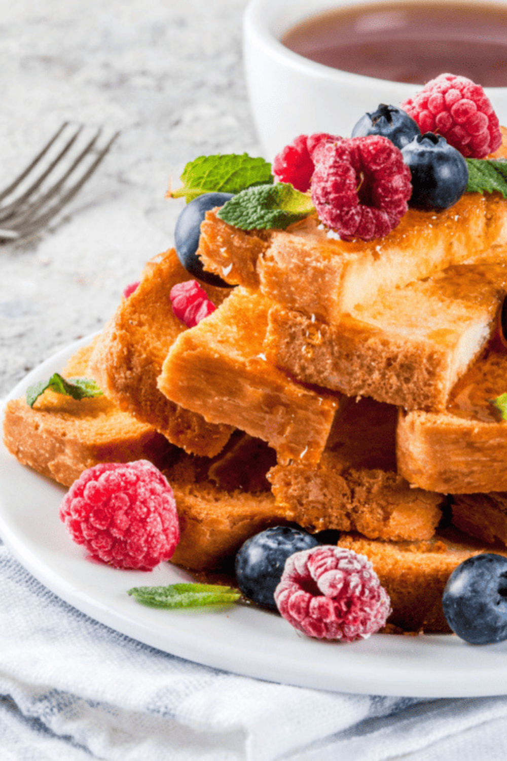 Air fryer French toast sticks, golden brown and crispy, served with syrup