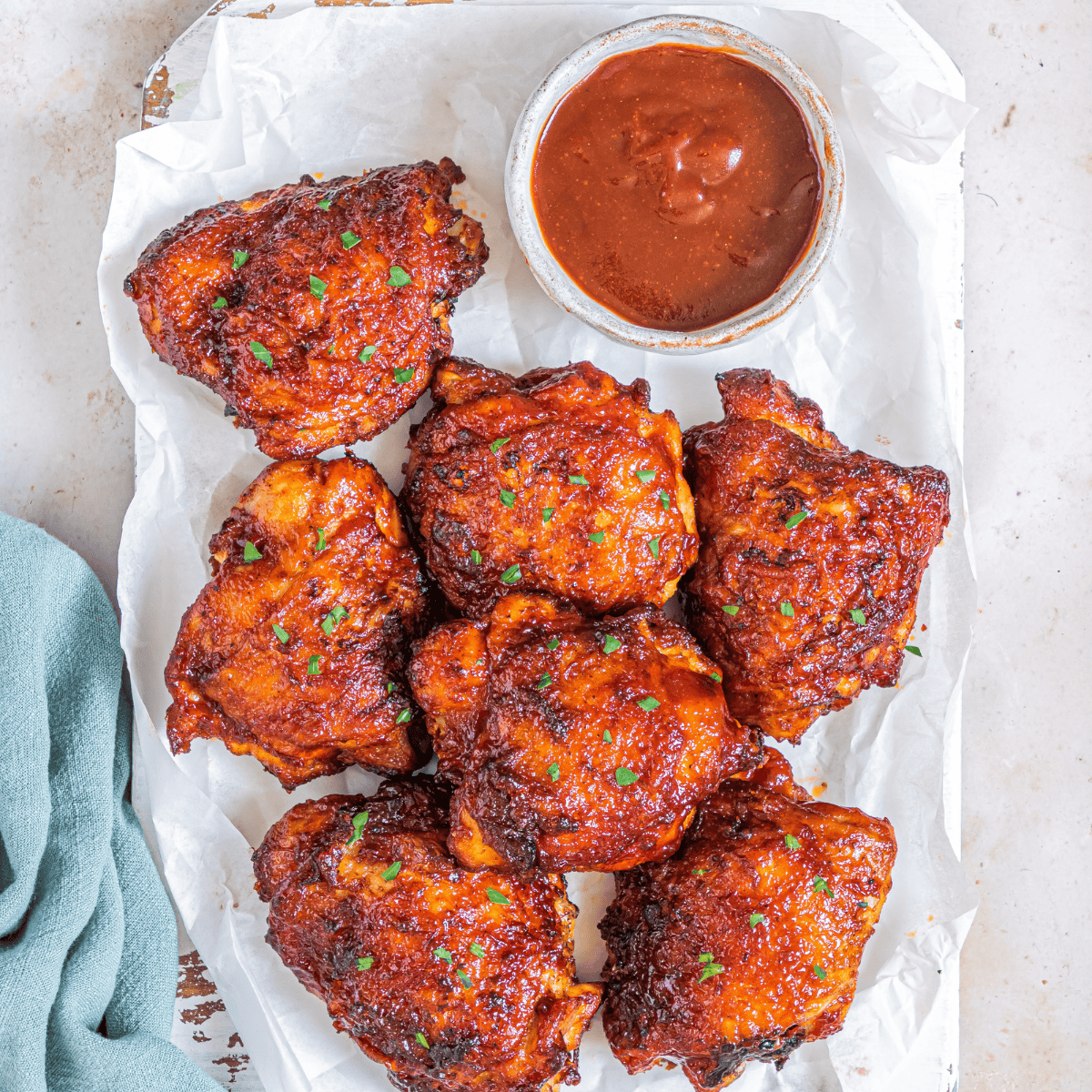 Frozen boneless skinless chicken thighs cooking in an air fryer basket without thawing