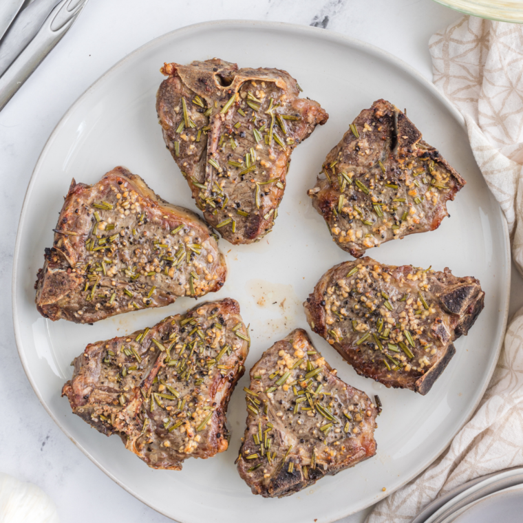 Reheated lamb chops served on a white plate