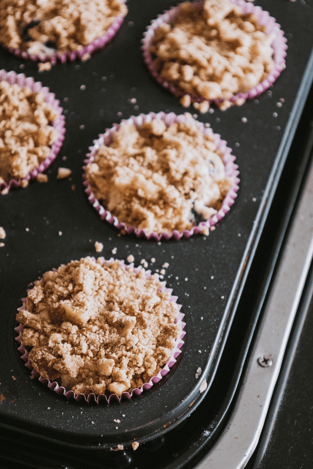 Mixing chopped nuts, flour, cinnamon, brown sugar, and butter by hand to create a loose crumble topping.