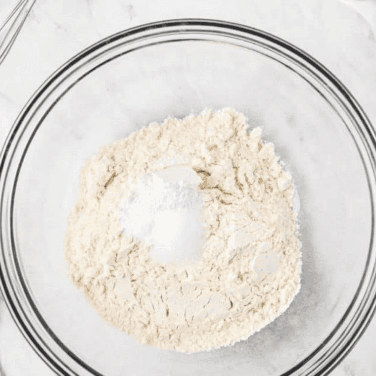 Whisking protein powder, flour, and baking powder in a glass mixing bowl
