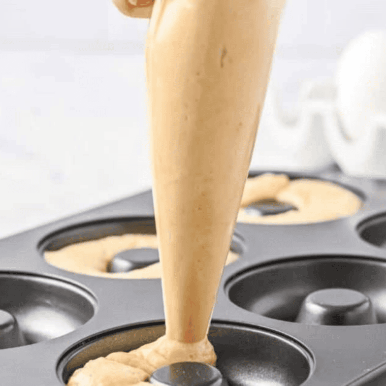 Piping protein donut batter into a silicone donut mold with a zip-top bag