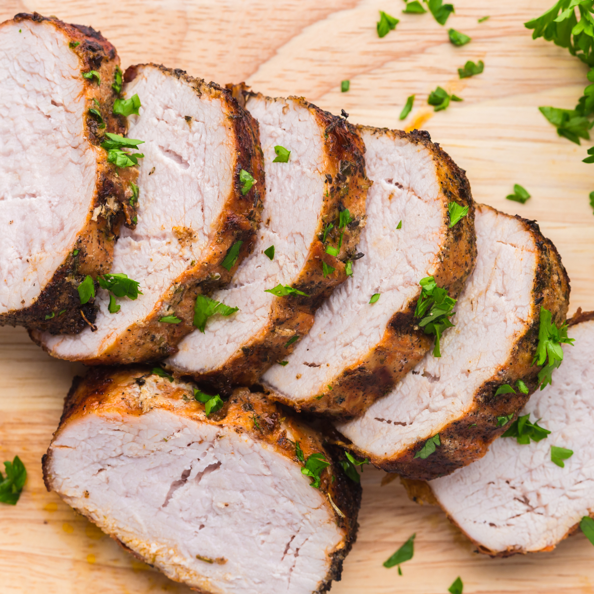 Frozen pork tenderloin cooking in an air fryer basket, sliced after cooking.