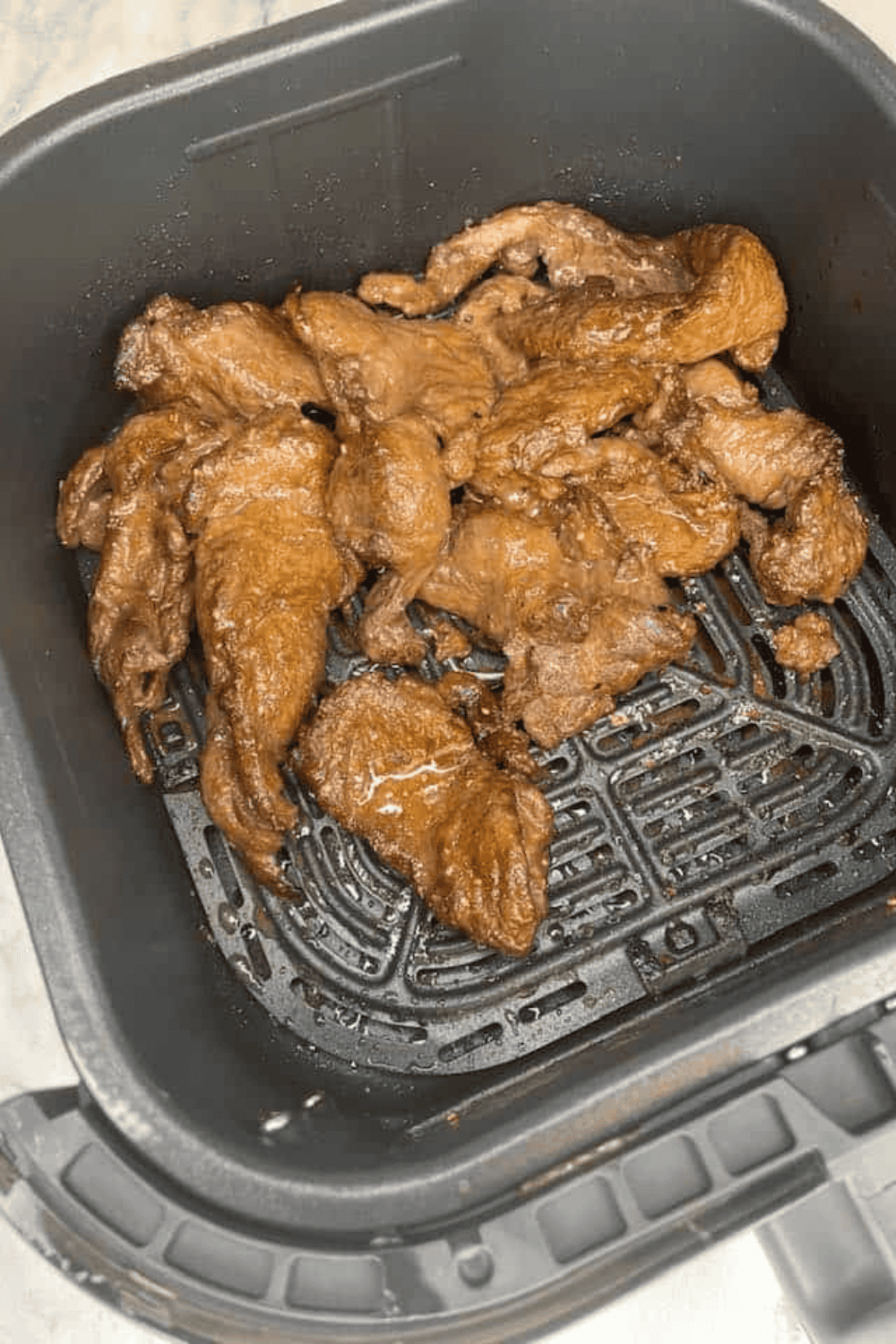 Trader Joe's Bool Kogi cooking in the air fryer basket, beef slices browning