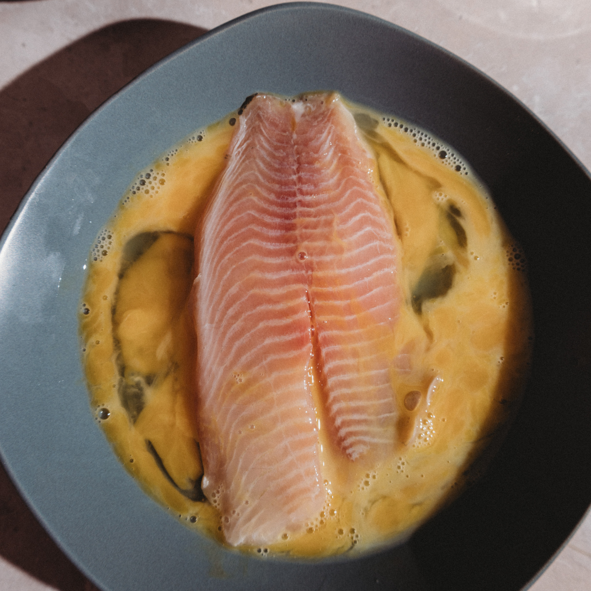 Blackstone griddle heating to 350–400°F for searing tilapia fillets evenly.