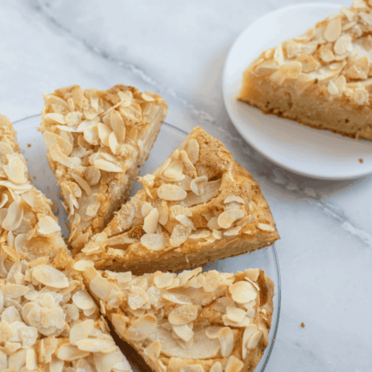 Easy air fryer almond cake with golden top, sliced and served on a plate.