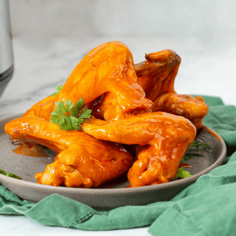 Golden-brown Ninja Foodi Buffalo Wings coated in spicy buffalo sauce