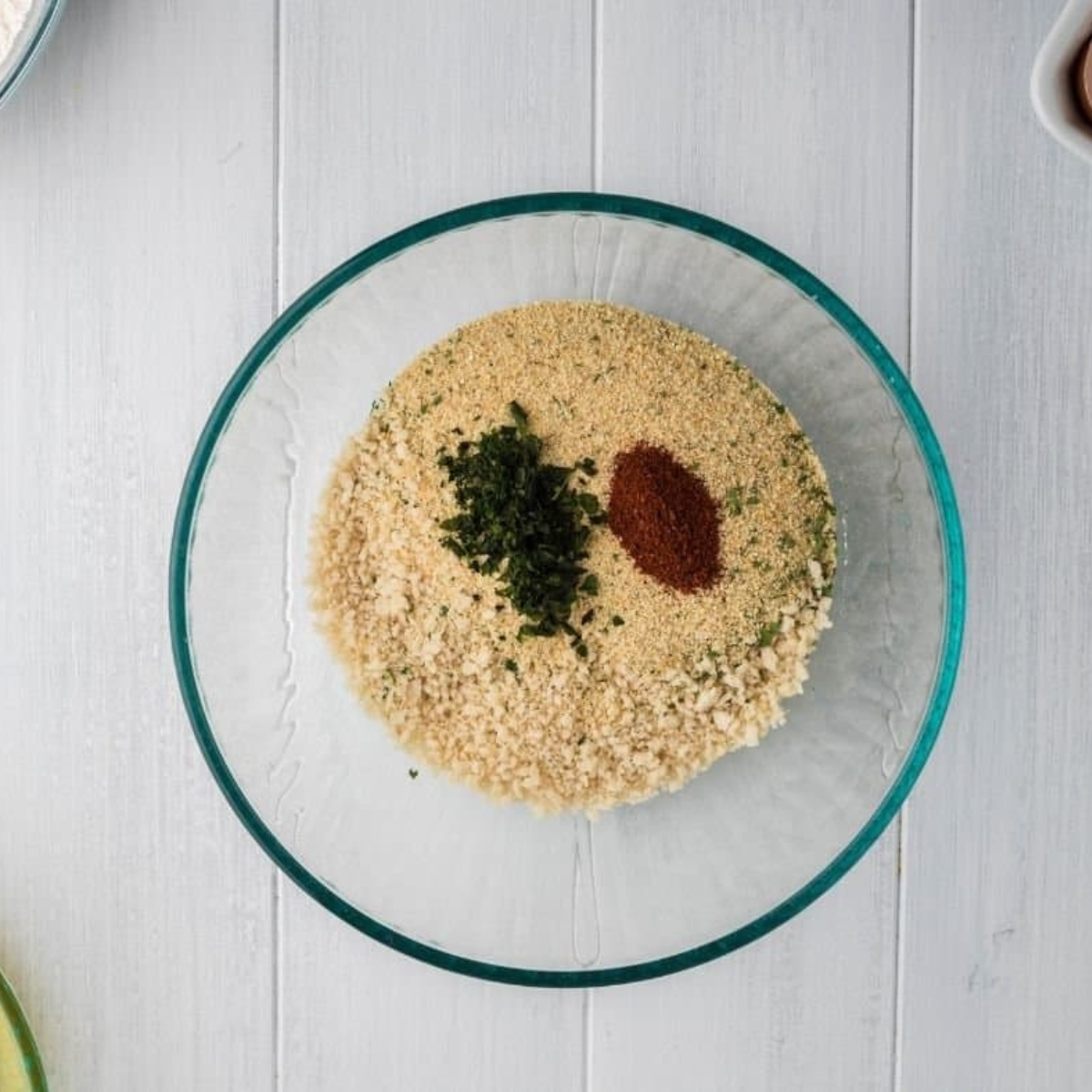 Breading station with bowls of flour, egg wash, and seasoned panko breadcrumbs