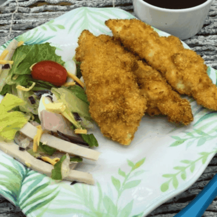 Golden brown, crispy Air Fryer Bojangles chicken tenders piled on a plate with honey mustard.