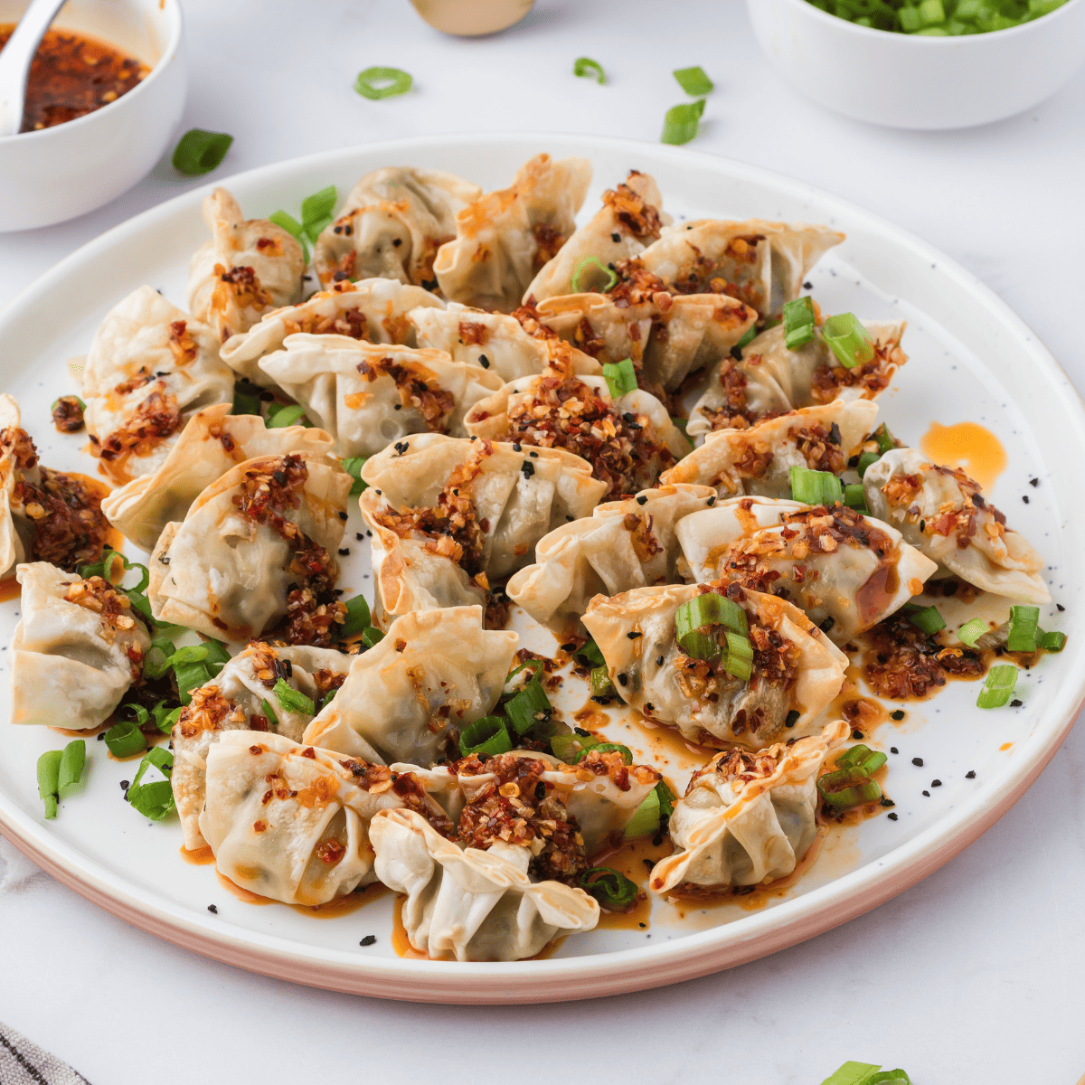 Plate of crispy air fryer Trader Joe's chicken cilantro mini wontons garnished with green onion