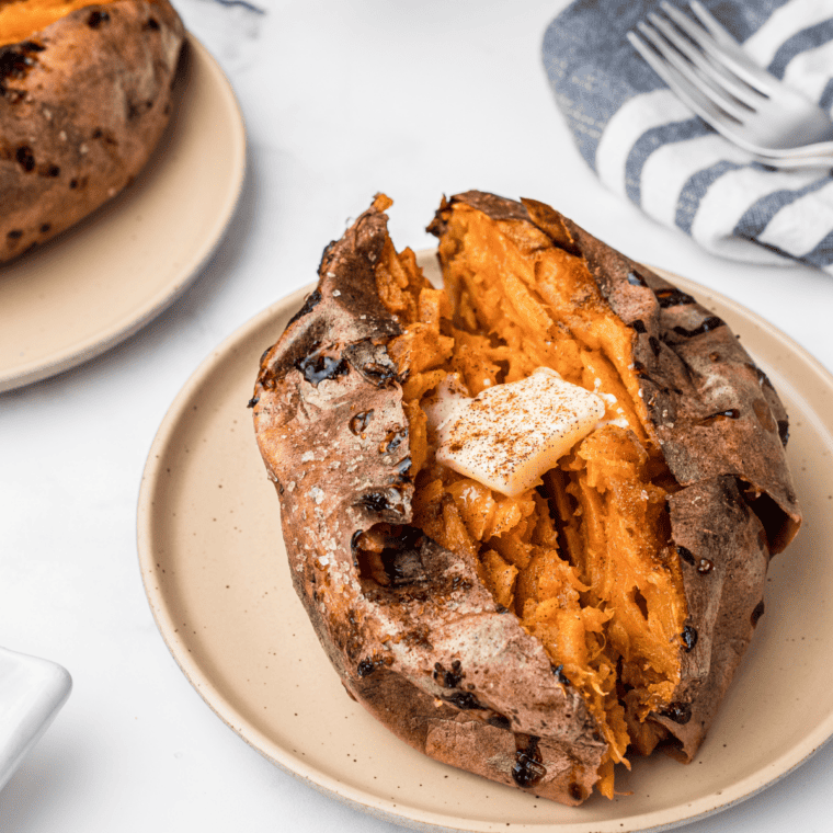 Copycat Outback Steakhouse sweet potato split open with honey cinnamon butter and brown sugar melting into the fluffy orange flesh