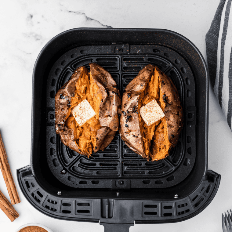 Air fryer Outback sweet potato split open and topped with brown sugar and melting honey cinnamon butter