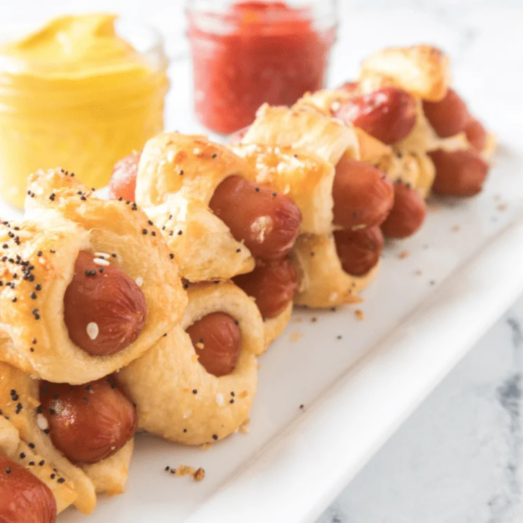 Air fryer bagel dogs on a white plate served with mustard and ketchup