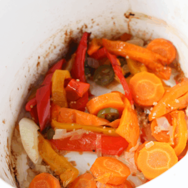 Add canned tomatoes, pasta, Cajun spices, and broth to the crock pot, cooking until the pasta is tender and fully cooked.