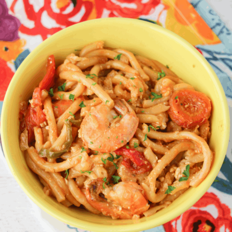 A plate of creamy Cajun Jambalaya Pasta with chicken, shrimp, sausage, and bell peppers, garnished with parsley.