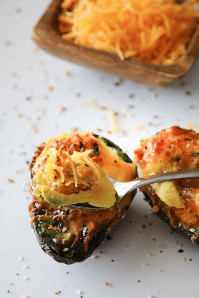 air fryer stuffed avocado with creamy savory filling on plate.