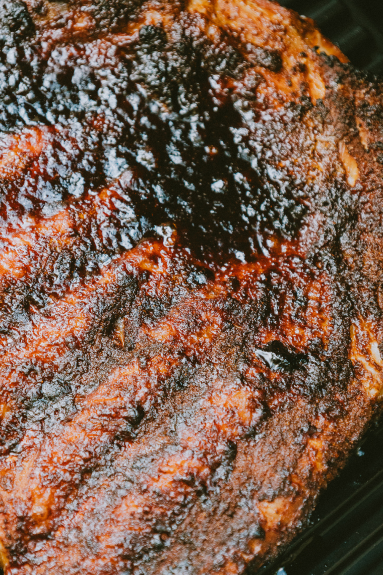 Checking ribs for doneness at 195–203°F and letting them rest on a cutting board before slicing for juicy, tender results