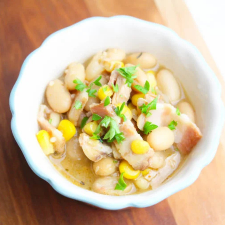 Spoonful of creamy turkey white bean chili lifted from a bowl, showing tender white beans and shredded turkey