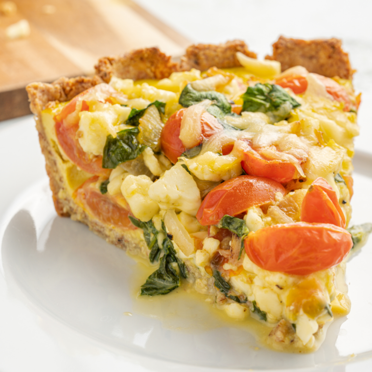 Slice of air fryer gluten-free quiche lifted from the pan, showing the almond flour crust