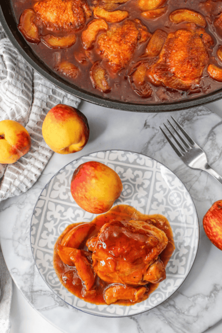 Crispy air fryer chicken thighs served with caramelized peaches on a plate.
