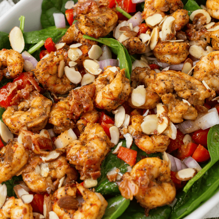 Grilled shrimp served on a fresh spinach salad with crispy bacon and bacon vinaigrette drizzle.