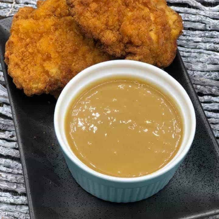 Chicken nugget being dipped into copycat Trader Joe's Carolina Gold BBQ sauce
