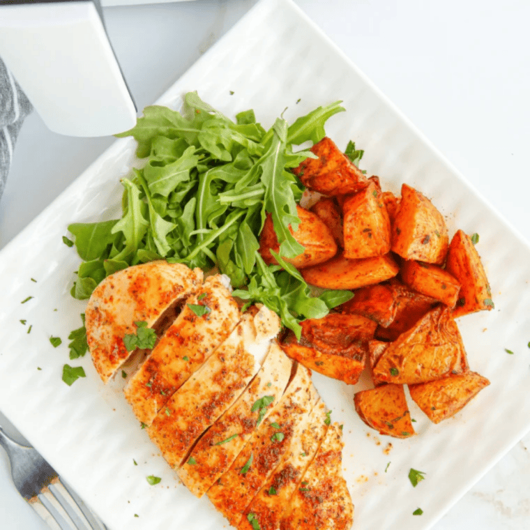 Juicy air fryer thin chicken breast sliced on a plate, showing a golden exterior and tender interior