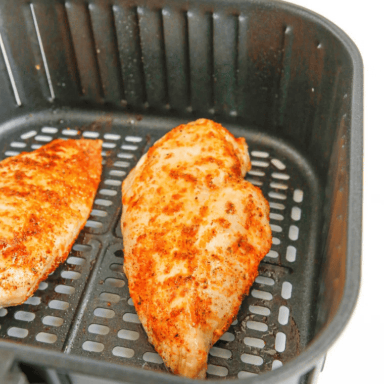 Instant-read thermometer checking air fryer thin chicken breast at 165°F