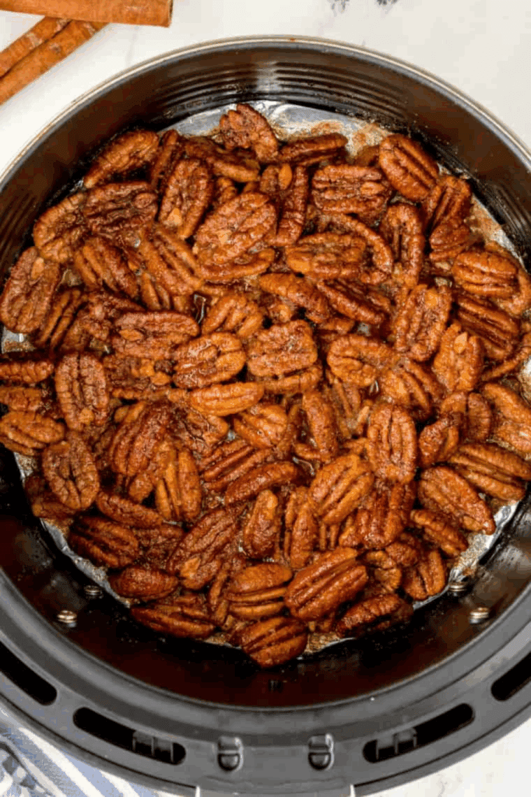 Air fryer gingerbread candied pecans coated in warm holiday spices, served in a bowl.