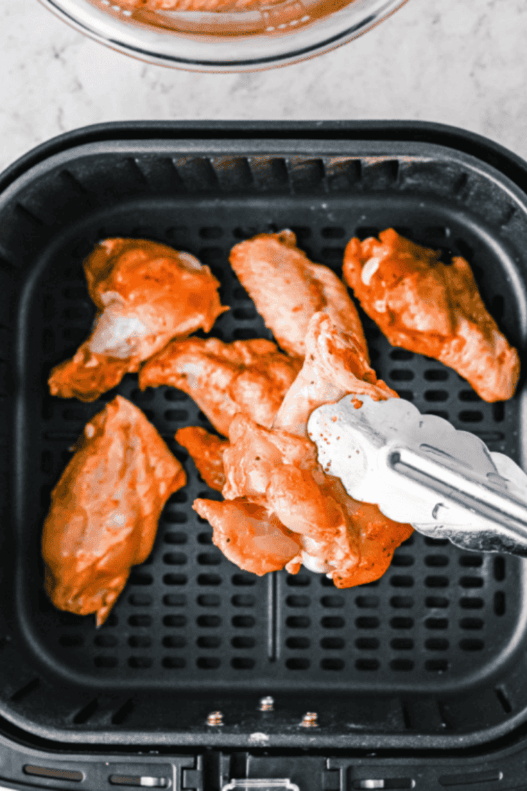 Wings cooking in an air fryer at 380°F, flipping halfway for even crispiness