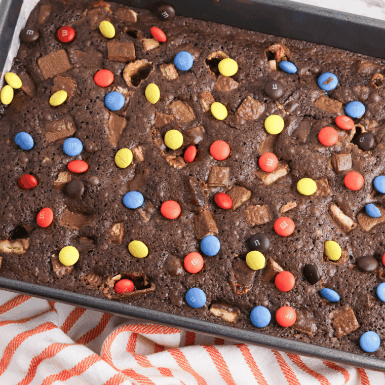 Fudgy brownies loaded with chopped leftover Halloween candy, served on a plate