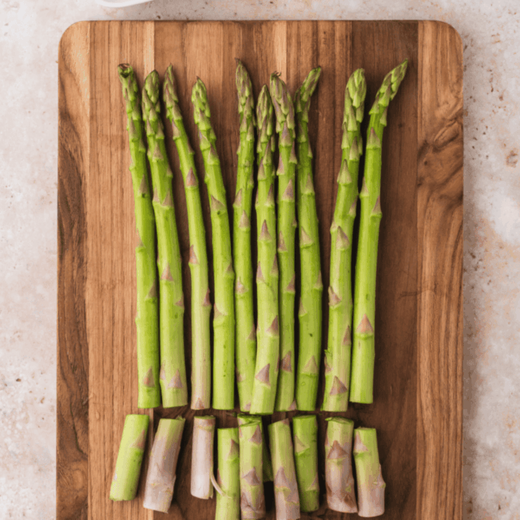 Preheating air fryer to 375°F while trimming woody ends from asparagus spears.