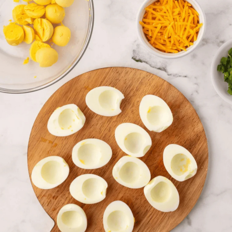 Halved hard-boiled eggs with the yolks removed for deviled egg filling