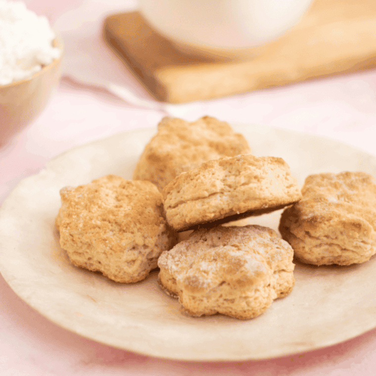 Golden, fluffy Air Fryer Lemonade Scones served on a plate with a lemon garnish.