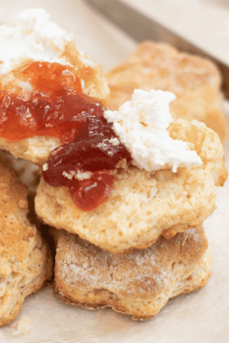 Plate of golden, flaky Air Fryer Lemonade Scones served with a dollop of jam and butter.