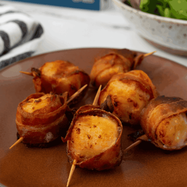 Crispy air fryer frozen bacon-wrapped scallops served on a plate, golden brown and ready to enjoy.